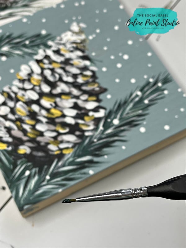 use a fine detail paintbrush and a flick of the wrist to paint evergreen pine needles The Social Easel