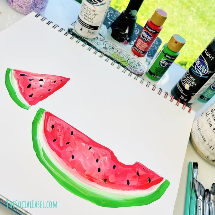 simple acrylic painting of two slices of watermelon on a notepad