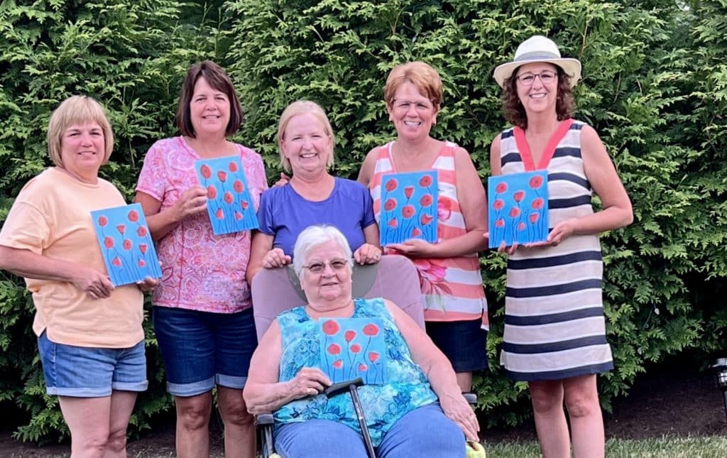 Charlene and friends holding their paintings of Poppies_Using Your Art to Reach Others_The Social Easel
