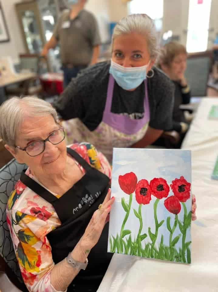 Two women posting together with a poppy painting_Using your art to reach others