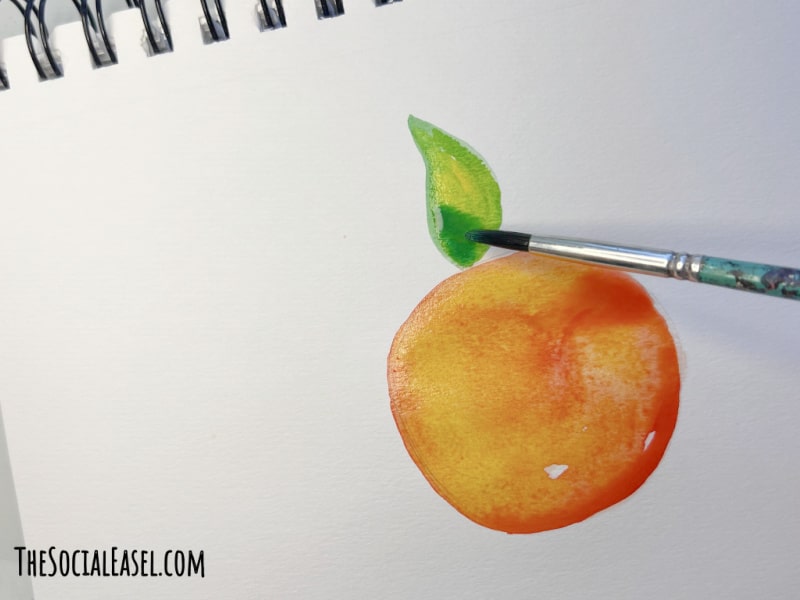 highlighting the orange leaf in my Watercolor Oranges Painting Tutorial