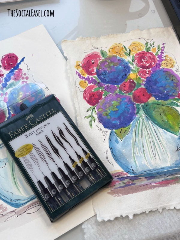 Faber-Castell 8 pack of pens next to the Colorful Watercolor Flower Arrangement painting on the desk