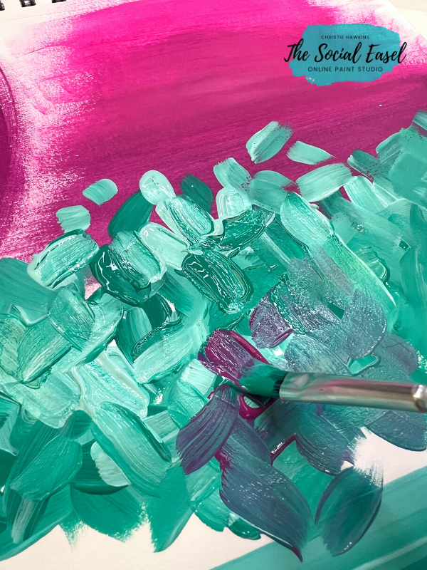 A close up image of turquoise and white brushstrokes that are not blended together. A small flat brush painting a few pink brushstrokes on top of the others.