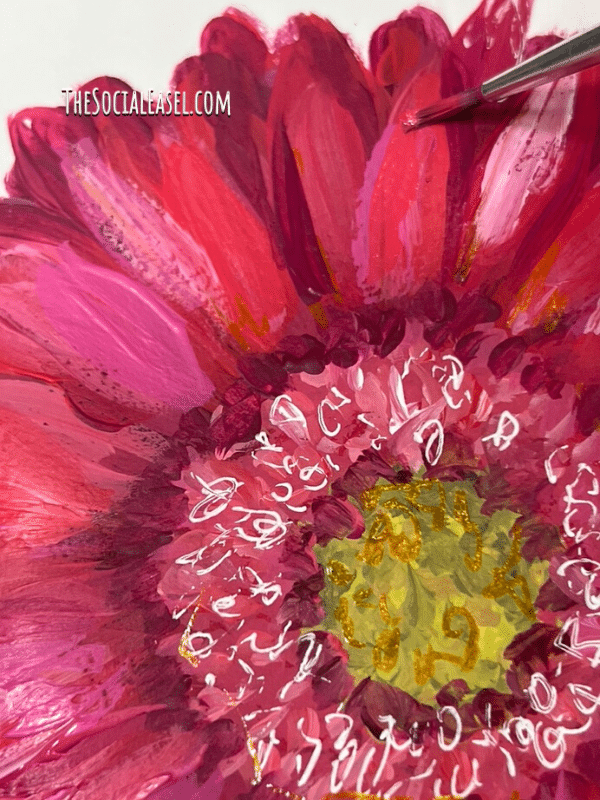 A gerbera daisy with multiple shades  of cactus flower, berry cobbler, cranberry wine, watermelon slice, matcha green, white, and black. A paint brush with watermelon slice paint on one of the petals of the flower. 