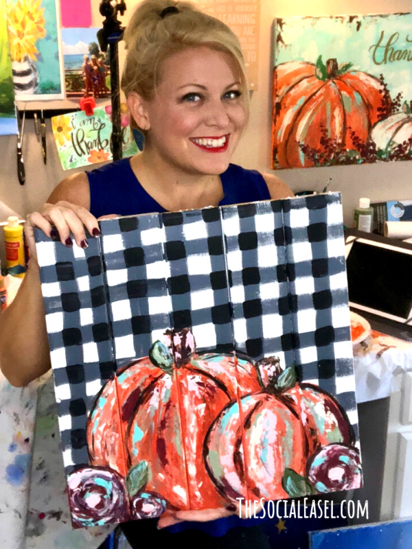 Christie Hawkins holding her Buffalo Plaid Rustic Pumpkins painted on a wood palette.