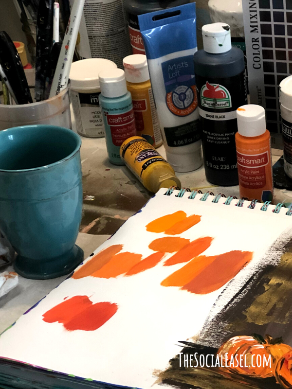 Several shades of orange painted on a mixed media pad using a mixing technique to create a lighter, darker, brighter, or softer shade of orange.