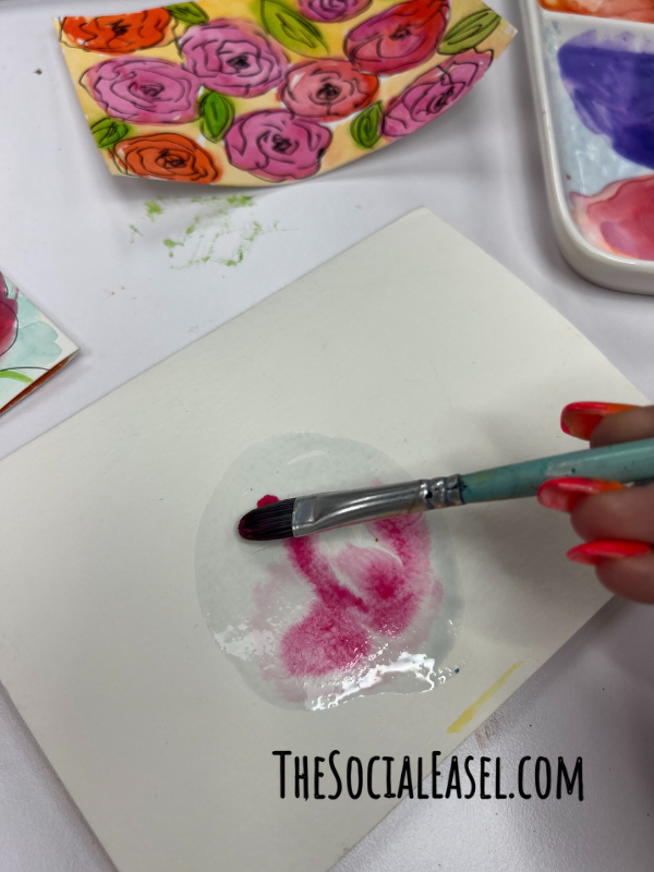 Using a paint brush to swirl around the watercolor paint.