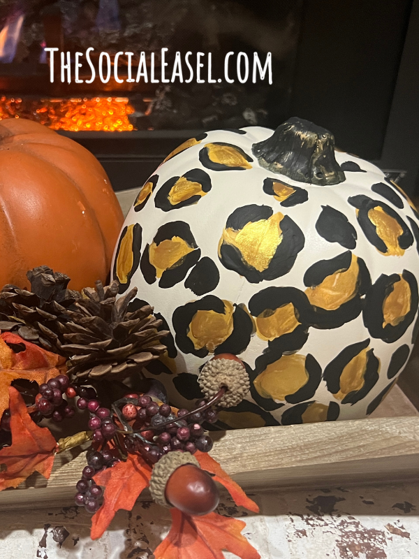 A gold and black leopard print on a white pumpkin.