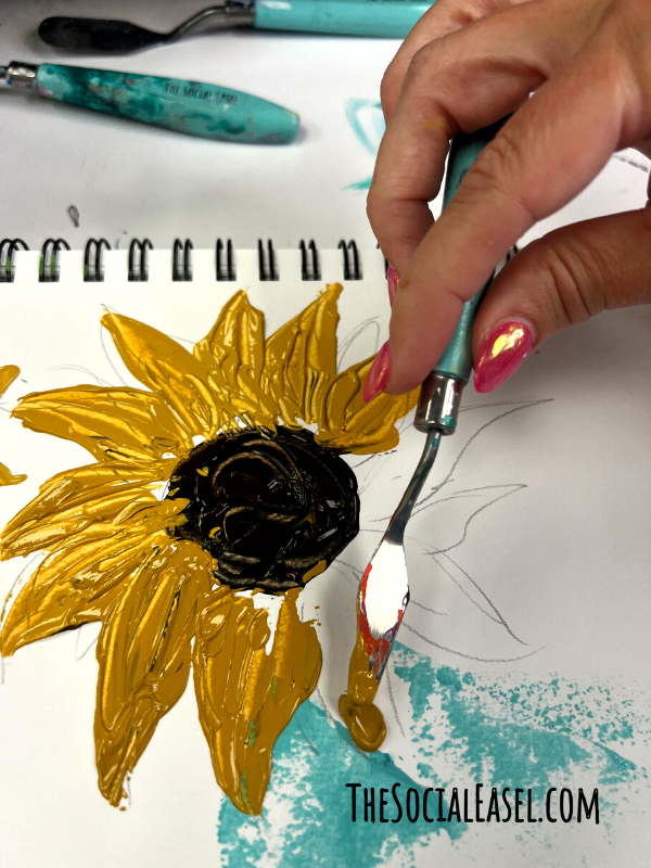 Golden petals are being create with a pallet knife.